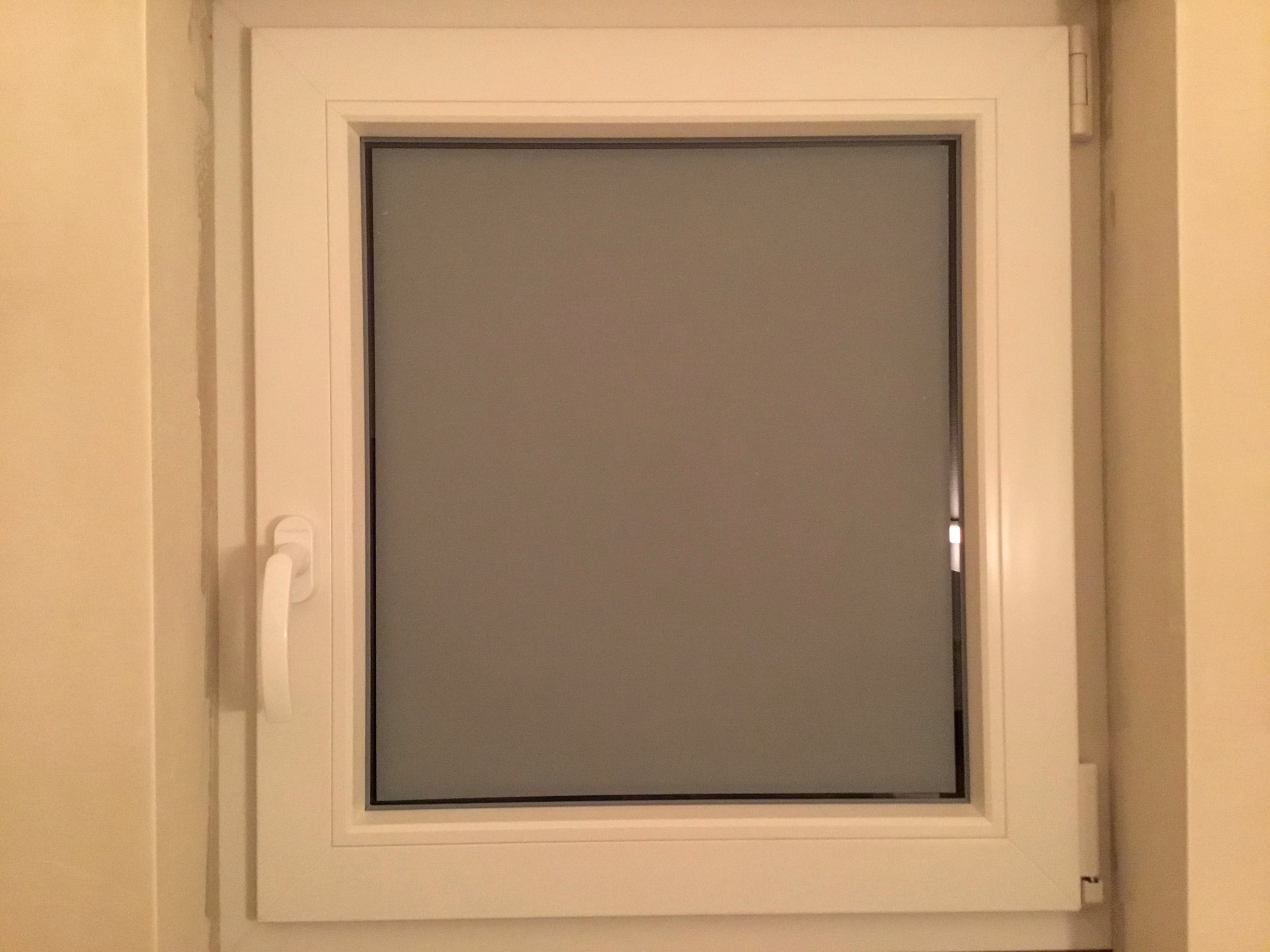 Adhäsionsfolie weiß matt auf einem kleinen Fenster Adhäsionsfolie weiß matt auf einem kleinen Fenster