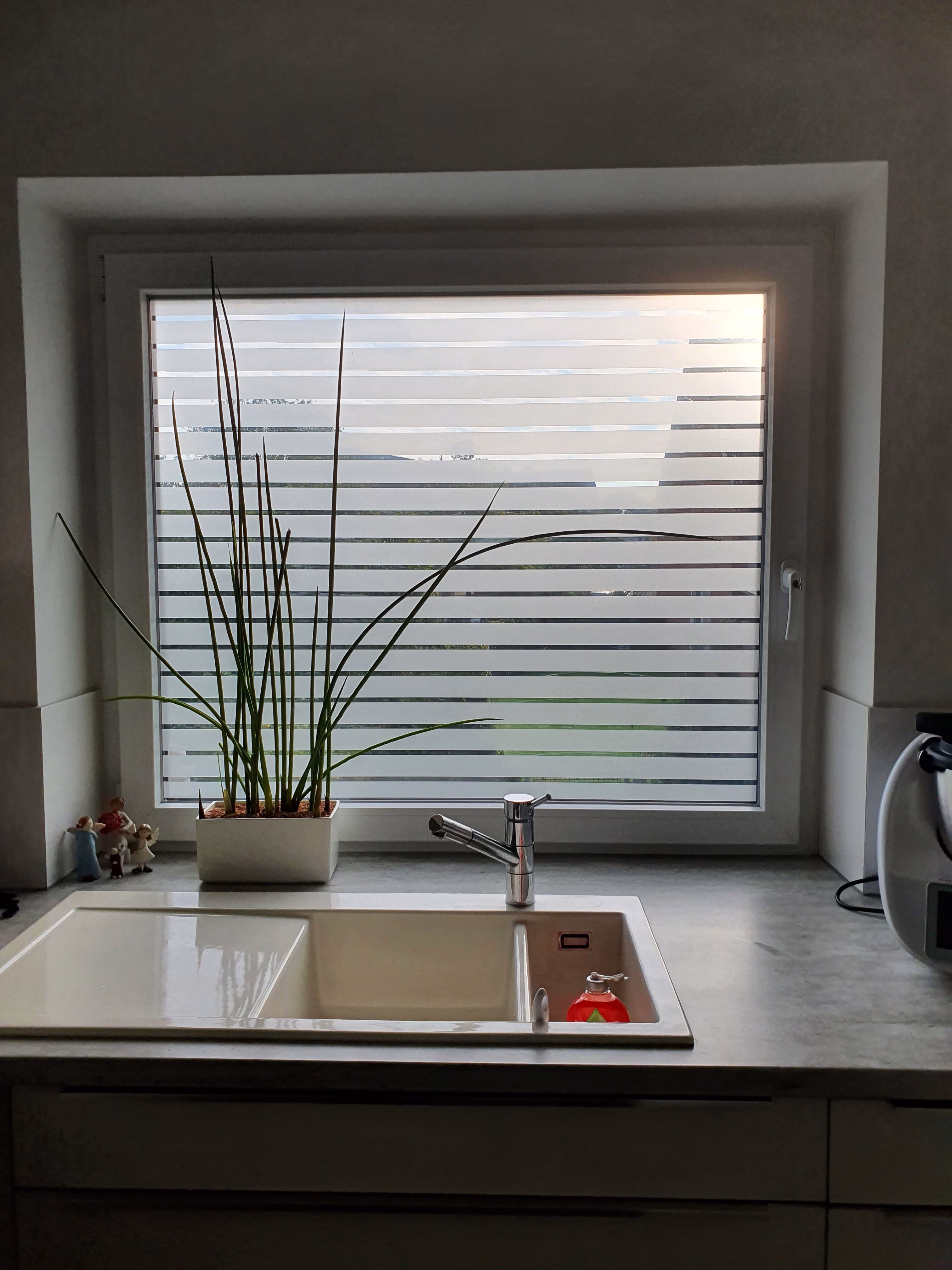 Streifenfolie auf Küchenfenster montiert mit Blick nach außen Streifenfolie auf Küchenfenster montiert mit Blick nach außen