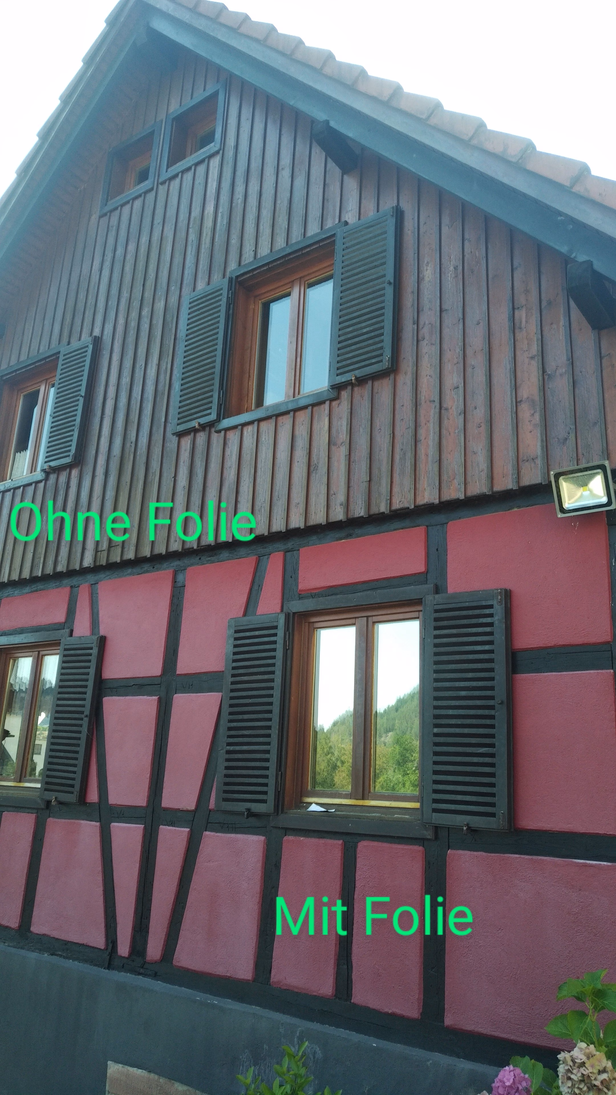 Mit Spionspiegelfolie folierte und unfolierte Fenster an einem Fachwerkhaus