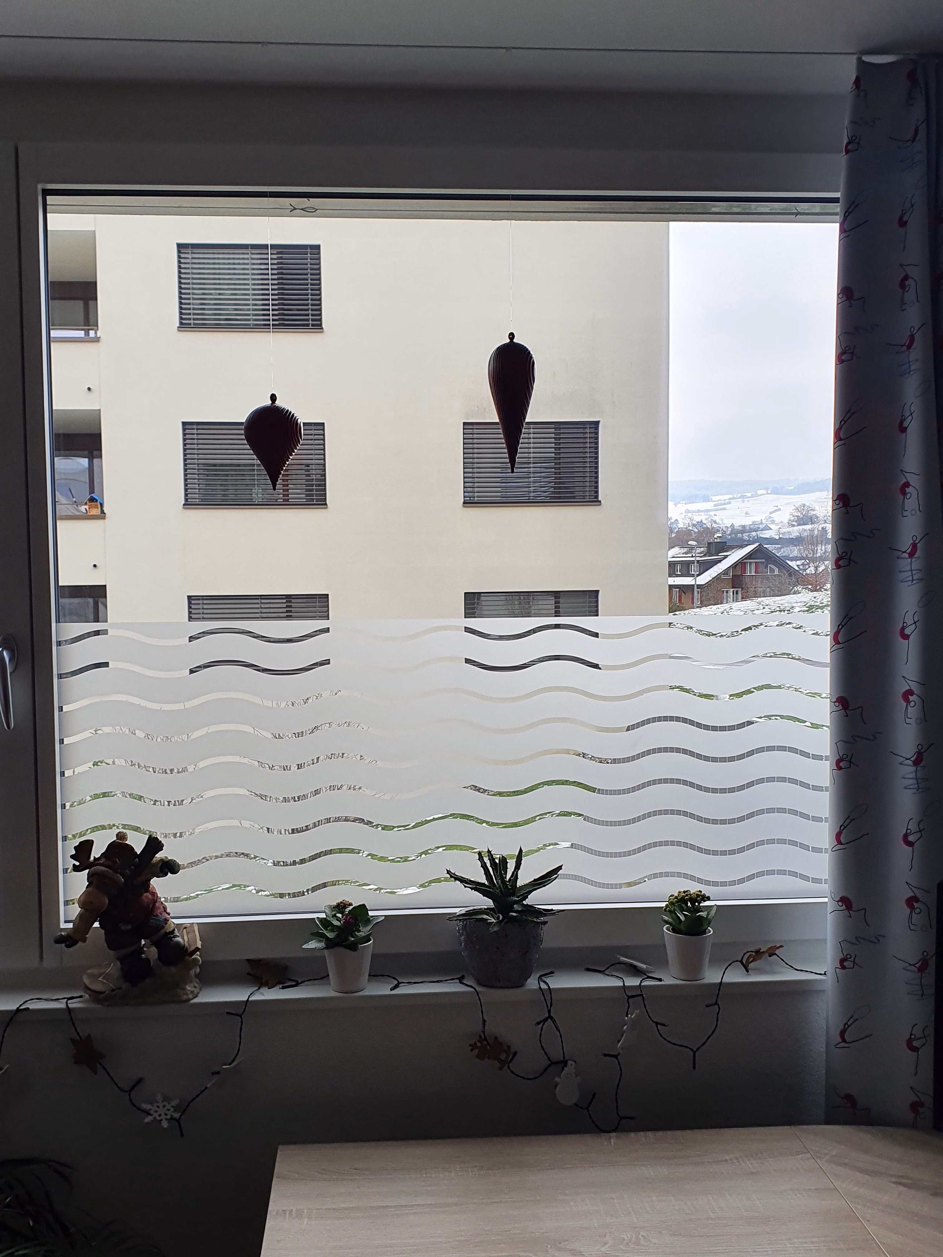 Dekorative Fensterfolie in Wellenoptik halbhoch auf einem Fenster angebracht
