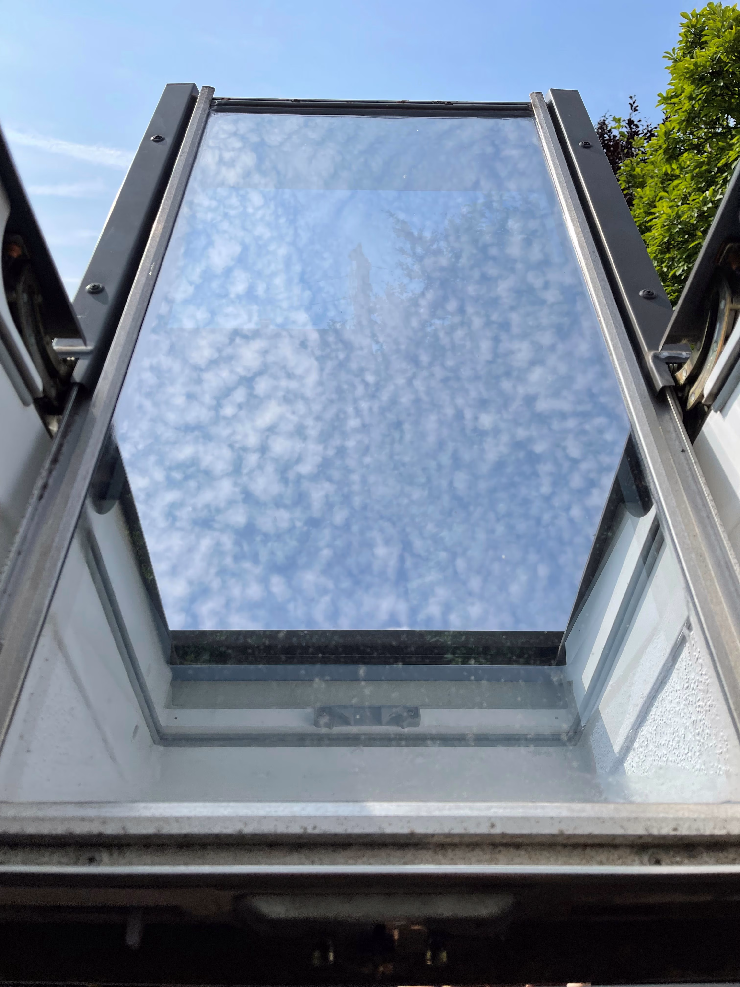 Spionspiegelfolie, silber verspiegelt auf einem Dachfenster Spionspiegelfolie, silber verspiegelt auf einem Dachfenster