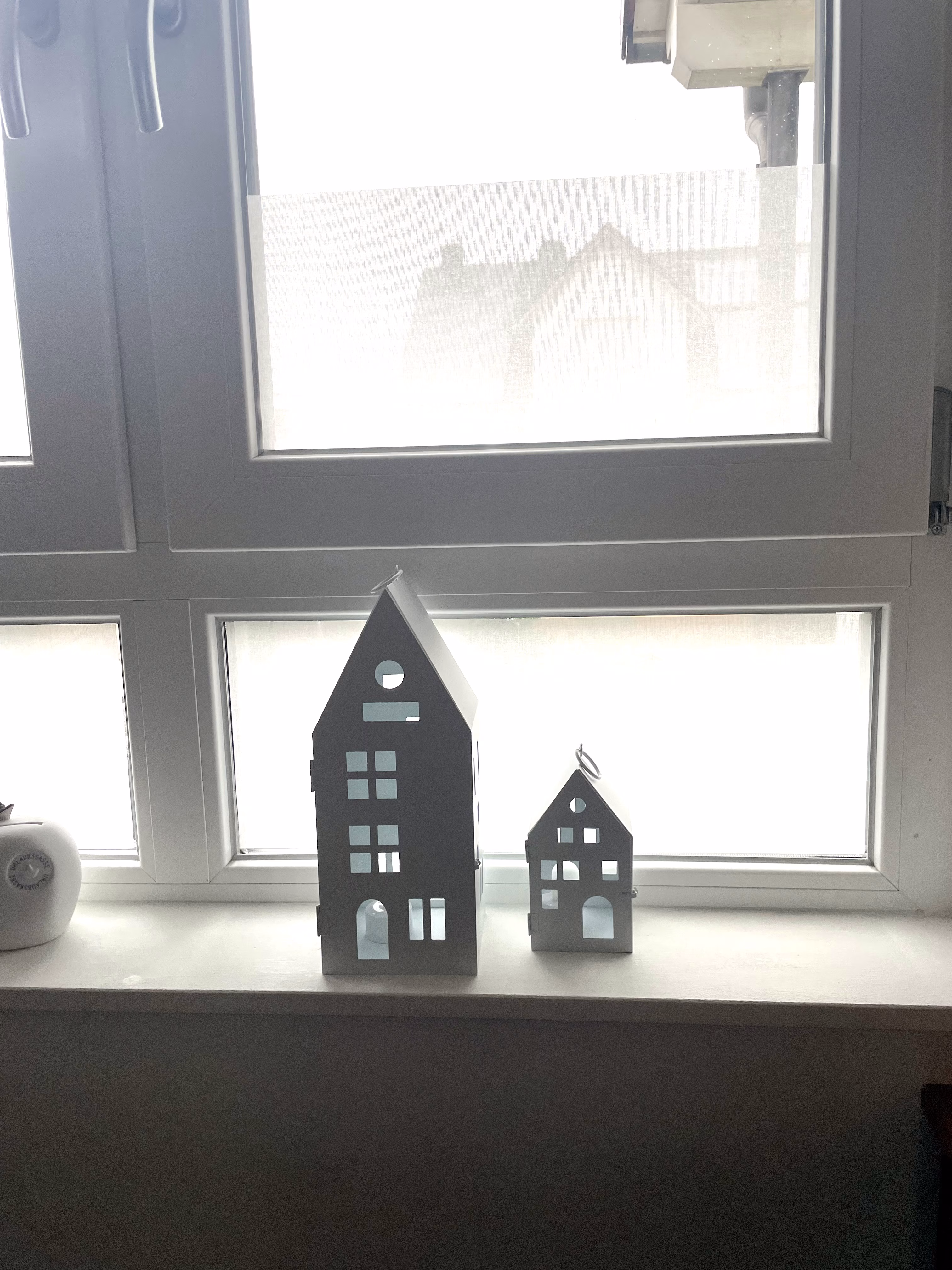 Weiße Textilfolie als Sichschutz auf einem Wohnzimmerfenster Weiße Textilfolie als Sichschutz auf einem Wohnzimmerfenster
