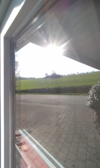 Detailansicht der Sonnenschutzfolie silber hell verspiegelt auf einem Fenster